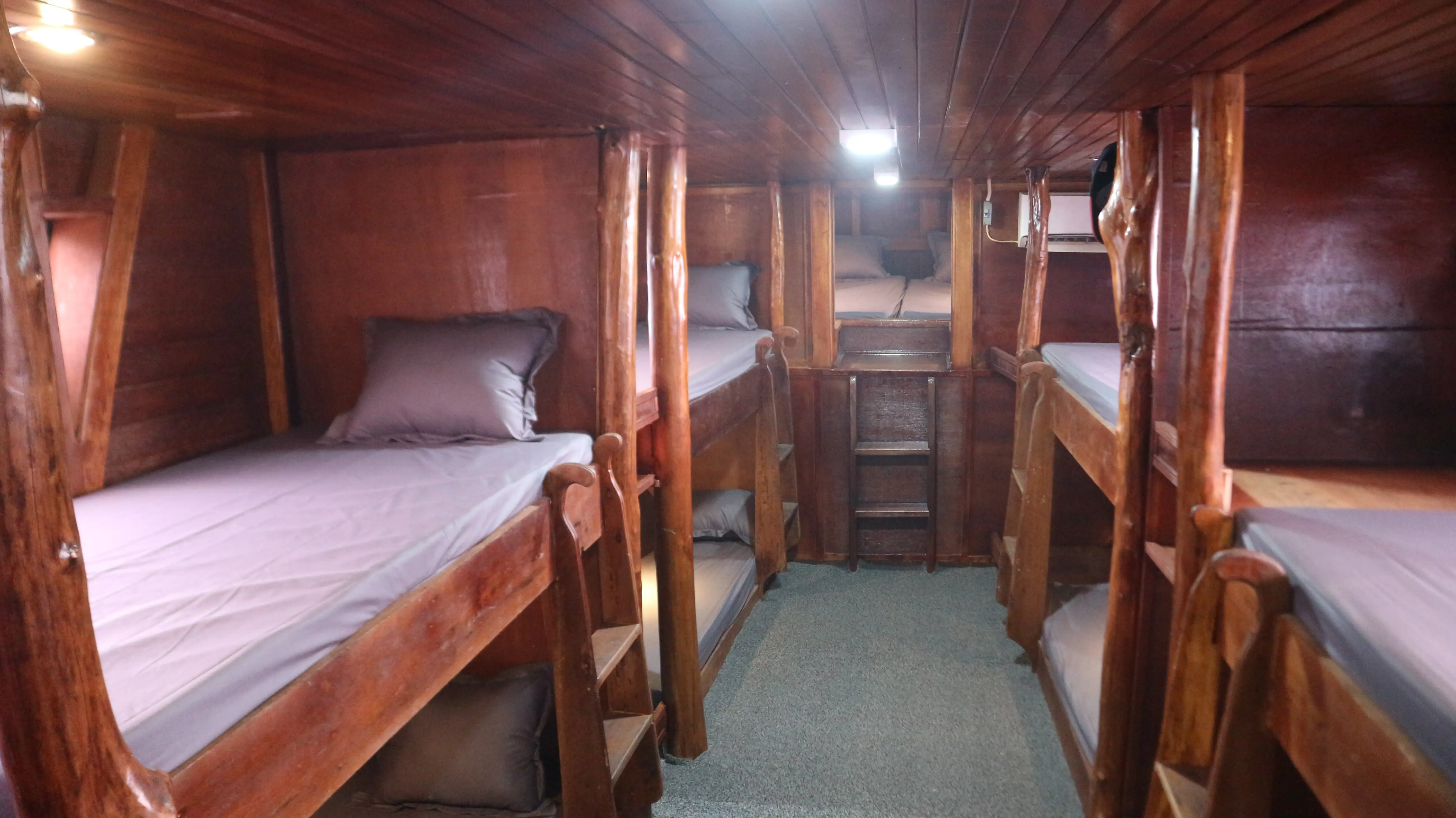 Bunk beds made up with grey linen below deck