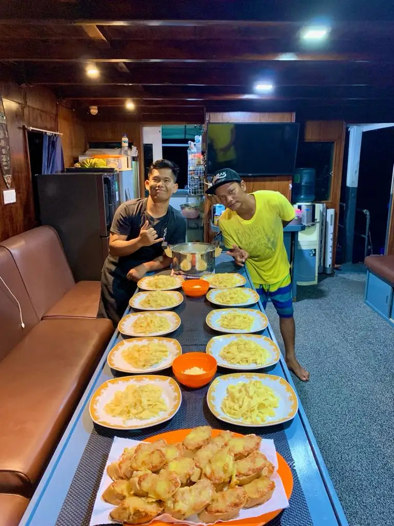 Crew presenting plated dinners in the boat's saloon
