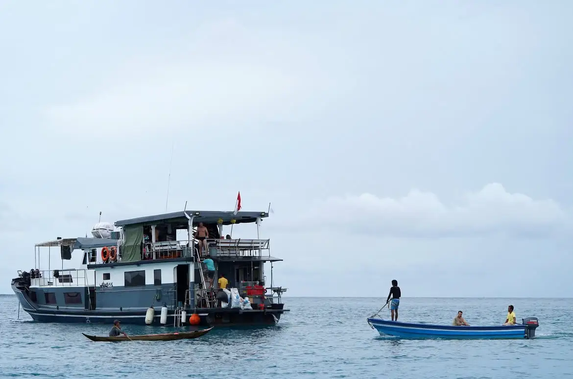 A local dugout canoe alongside the anchored charter boat