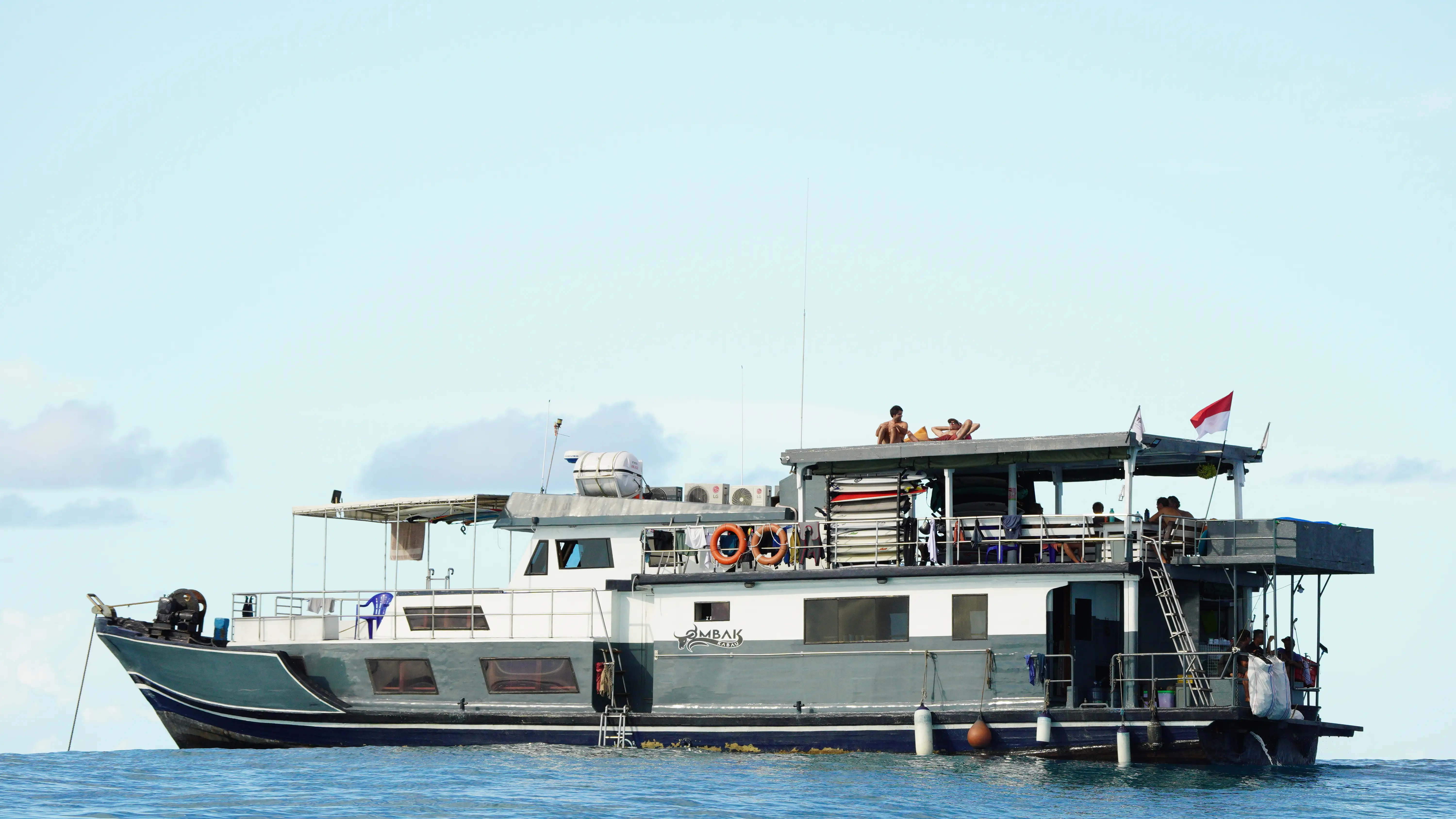 Guests relaxing on the upper sun deck at anchor