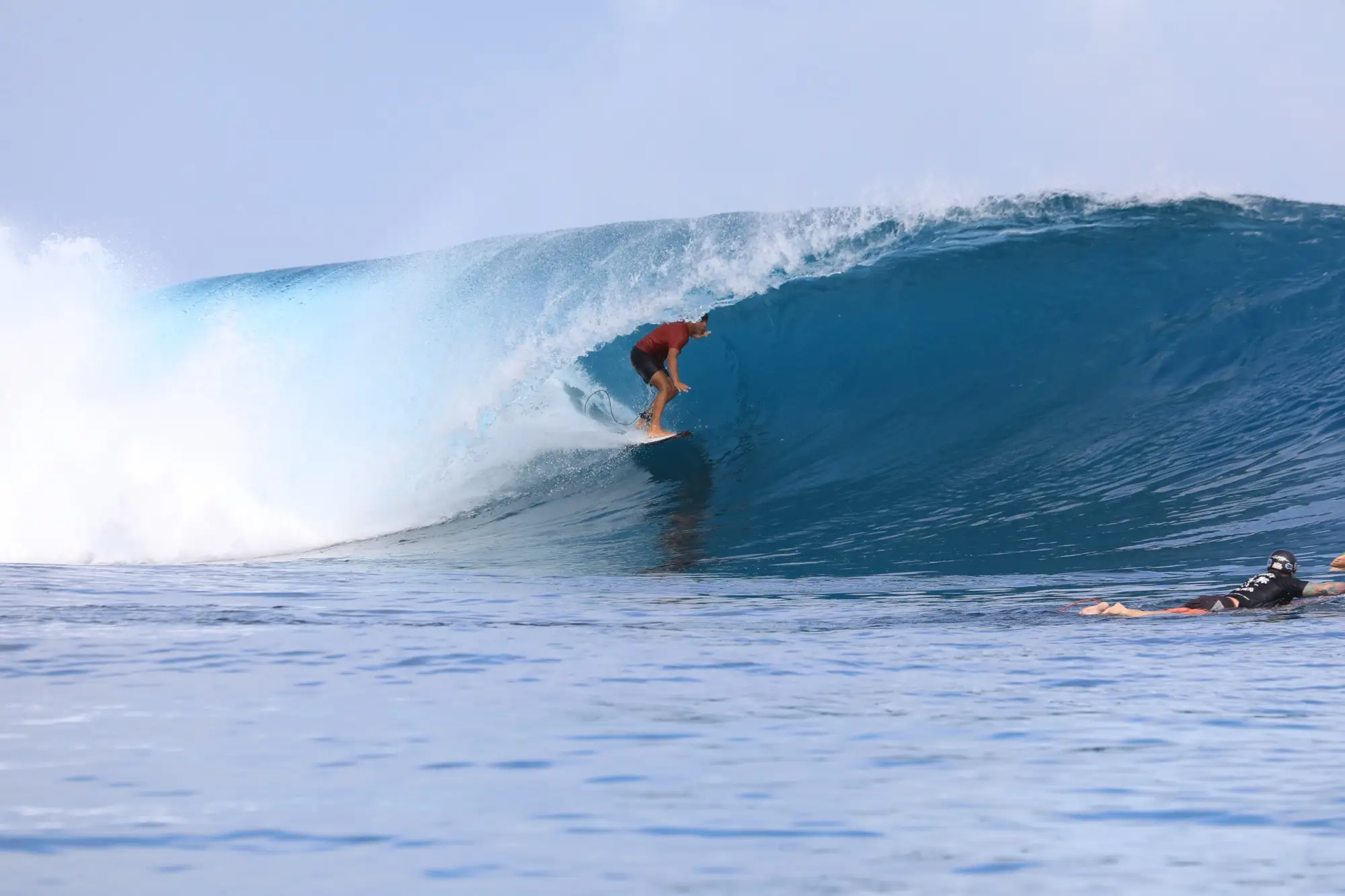 Surfer setting up under the lip while a photographer swims in the foreground