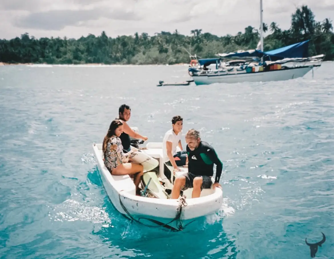 Guests riding a small tender across turquoise water to the surf