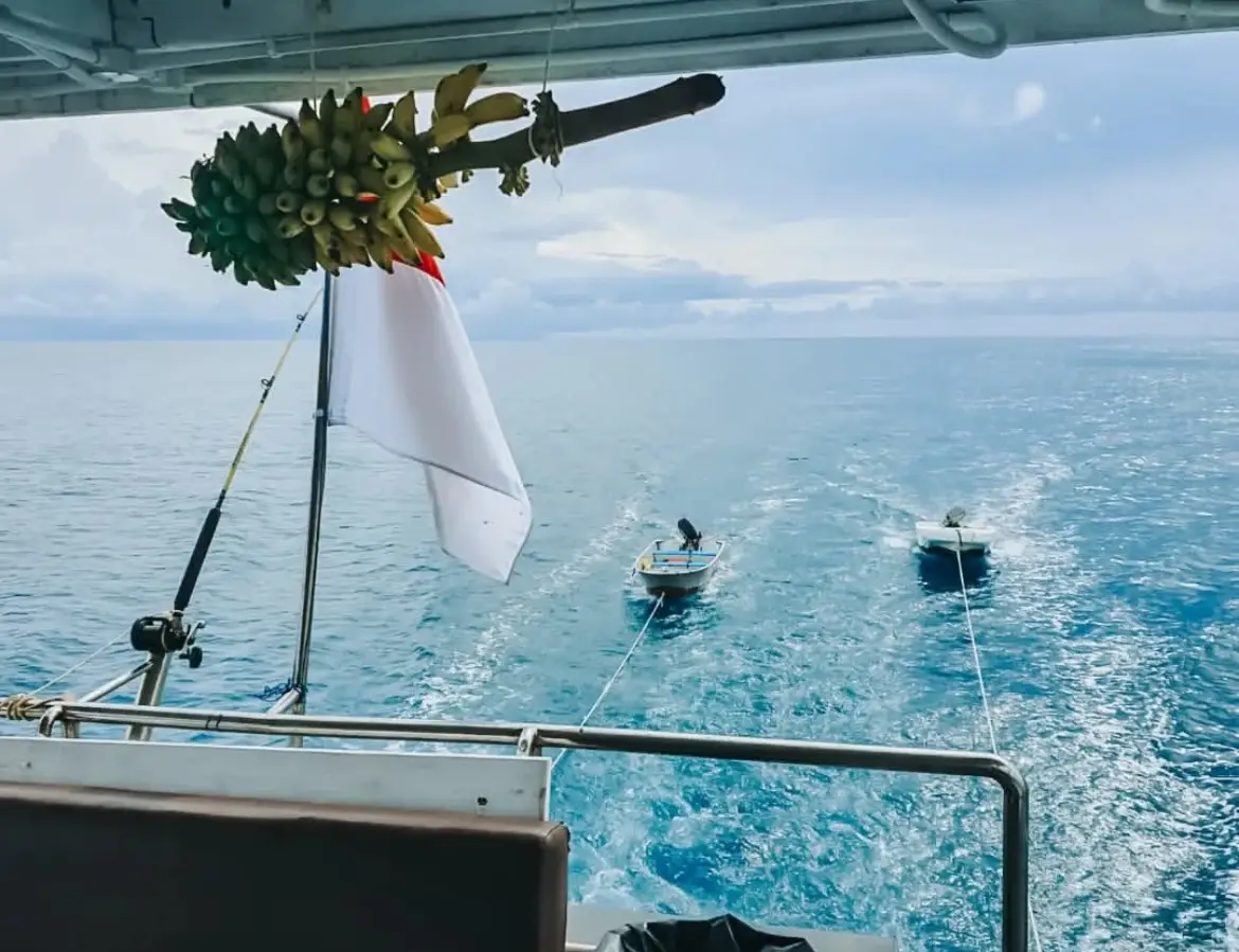 Two tender dinghies towed in the boat's wake on the way to the surf